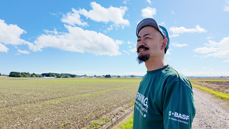 広大な圃場を背に語る白鳥さん